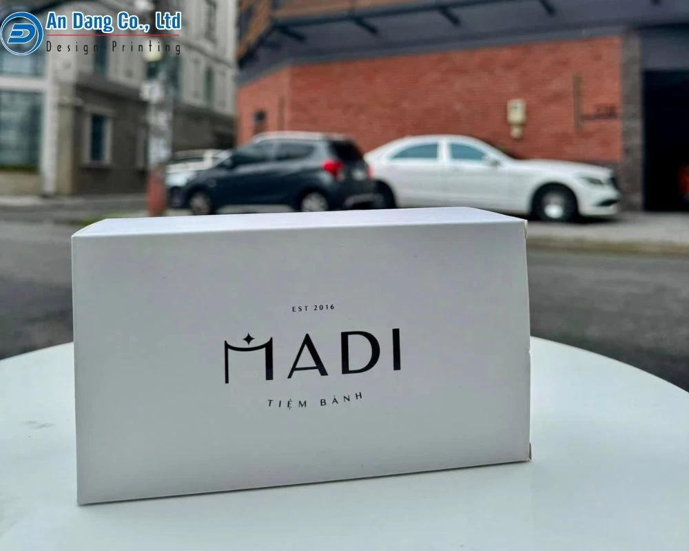 Mẫu hộp giấy đựng bánh ngọt màu trắng với logo hiện đại